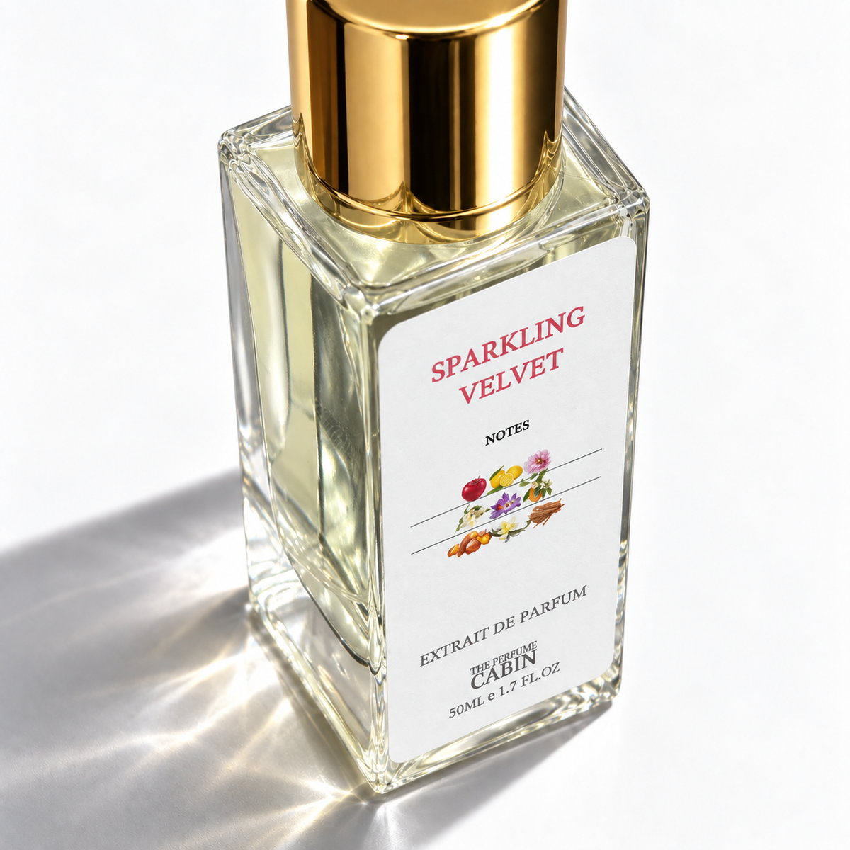 A 50ml glass bottle of Cabin Notes 'Sparkling Velvet' extrait de parfum, featuring a reflective gold cap and a white label with red and black text, set against a bright white background with soft shadows.