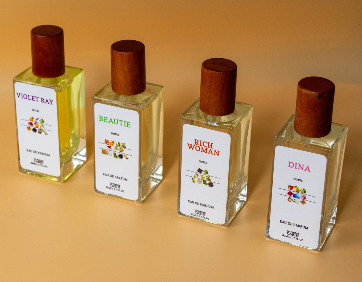 4 PERFUME BOTTLES, SIDE TO SIDE, VIOLET RAY, BEAUTIE, RICH WOMAN, DINA PERFUME, ALL LOKING LEFT PHOTO