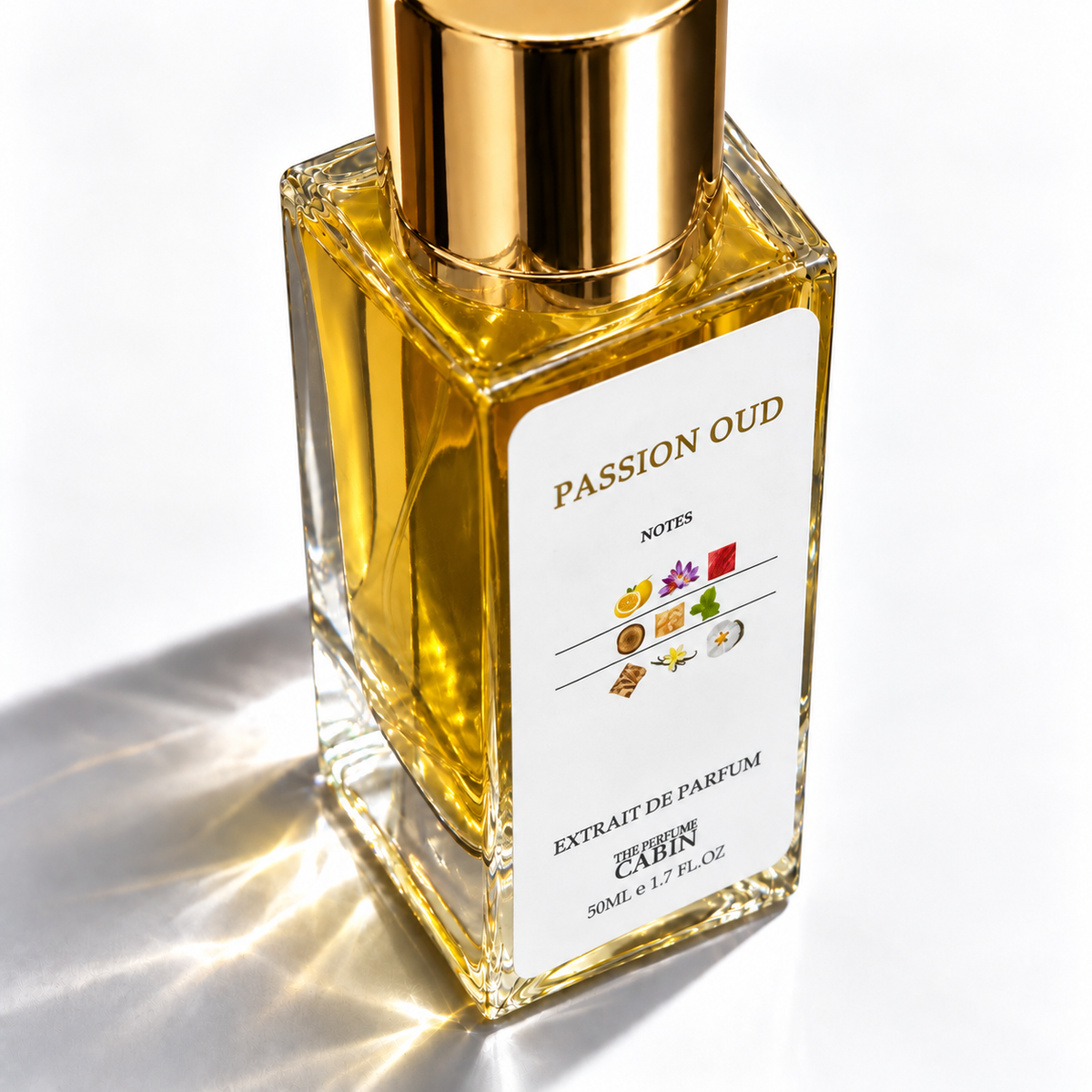 A square glass perfume bottle filled with golden-yellow liquid, topped with a reflective gold cap. The front label reads "PASSION OUD" and "CABIN" with small colorful scent notes illustrations.